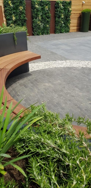 curved seat with artificial green wall panels in background