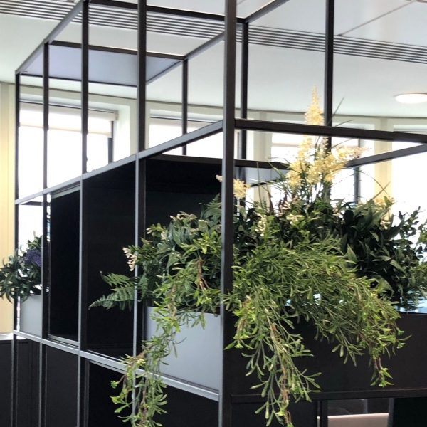 Adding faux green plants to liven up the office divider units